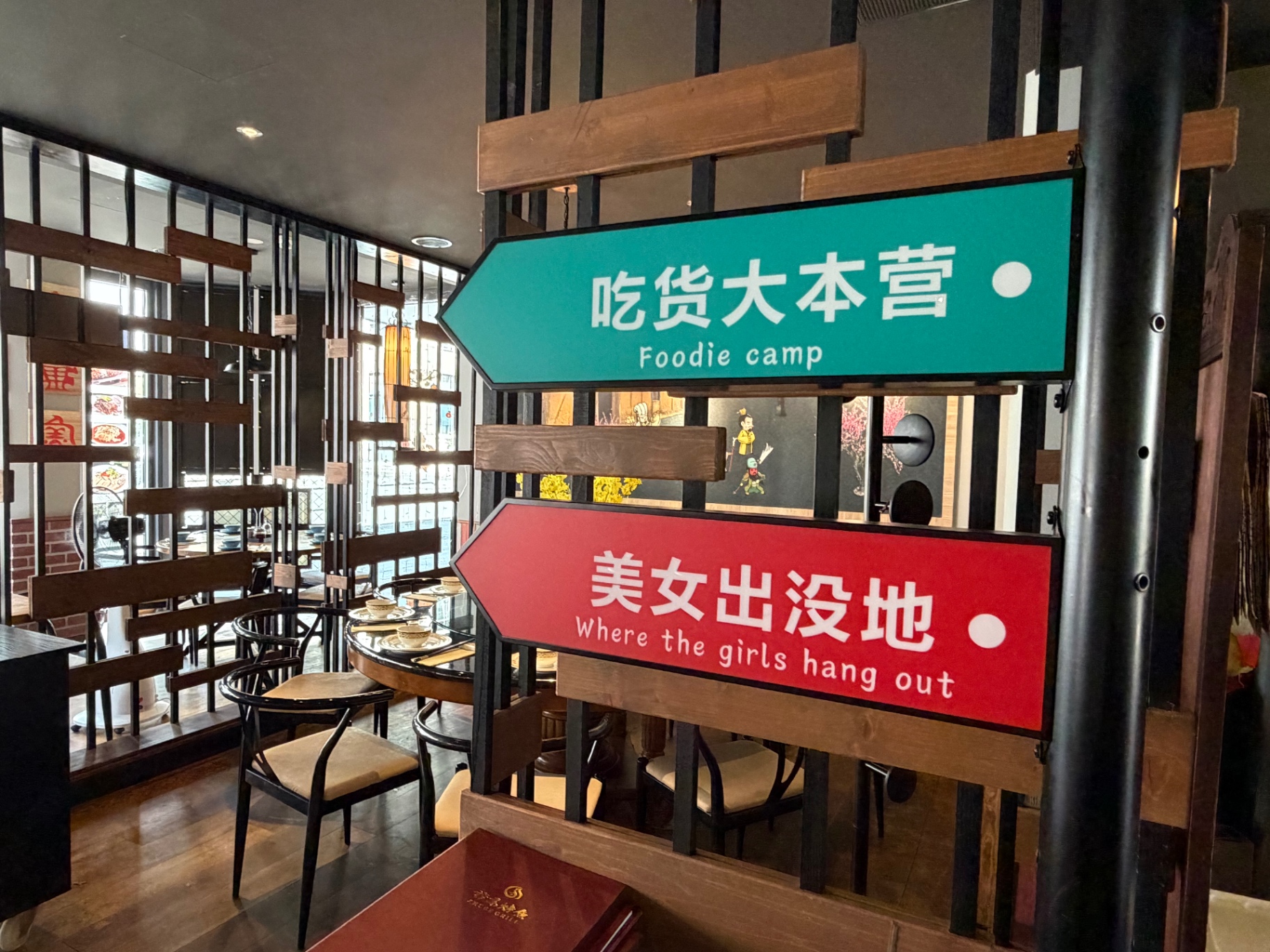 Wegweiser-Schilder ‚Foodie camp' und ‚Where the girls hang out' im Restaurant