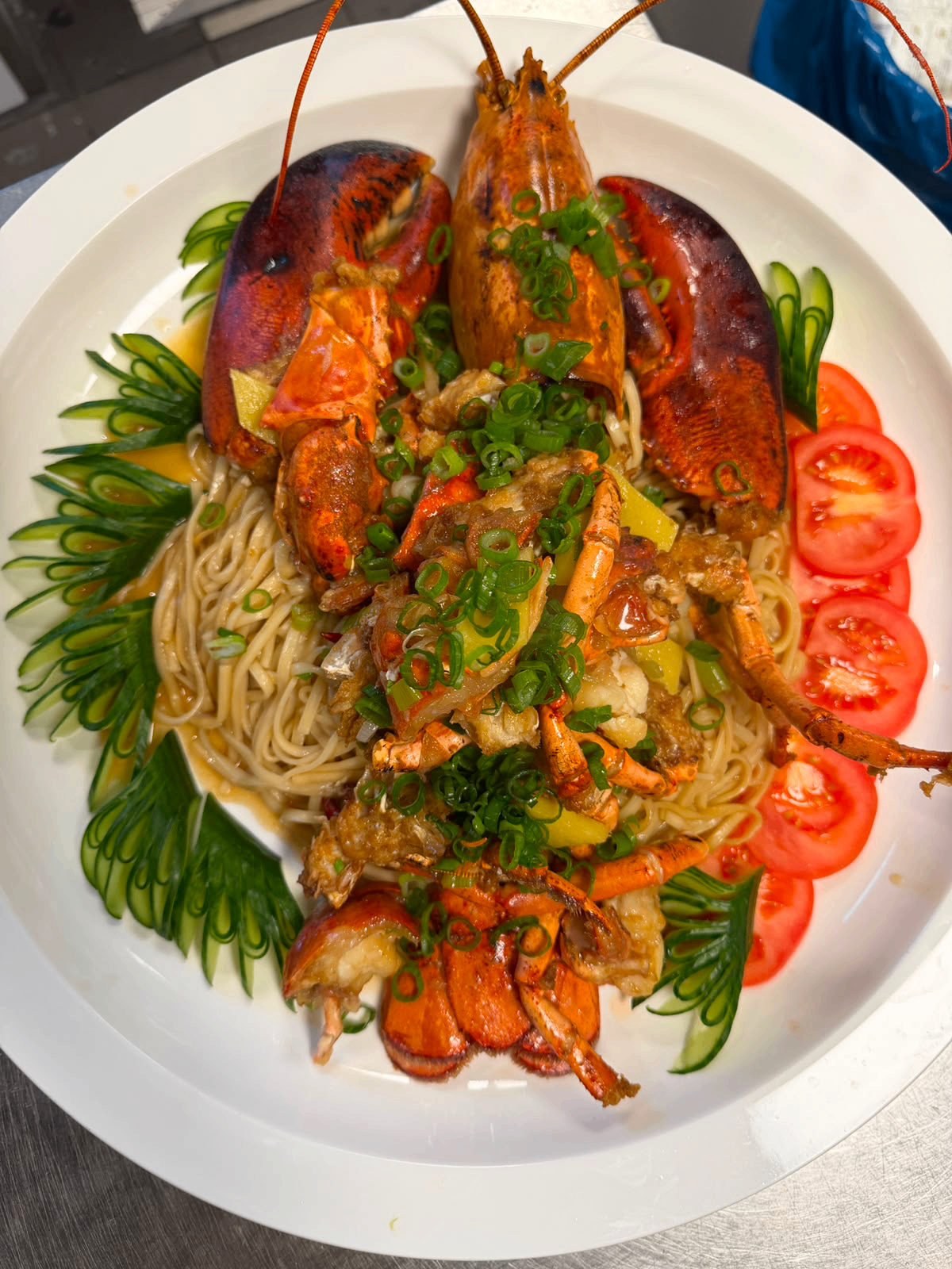Nudeln mit Hummer 龙虾面 – ganzer Hummer auf handgezogenen Eiernudeln mit Frühlingszwiebeln, Gurke und Tomate