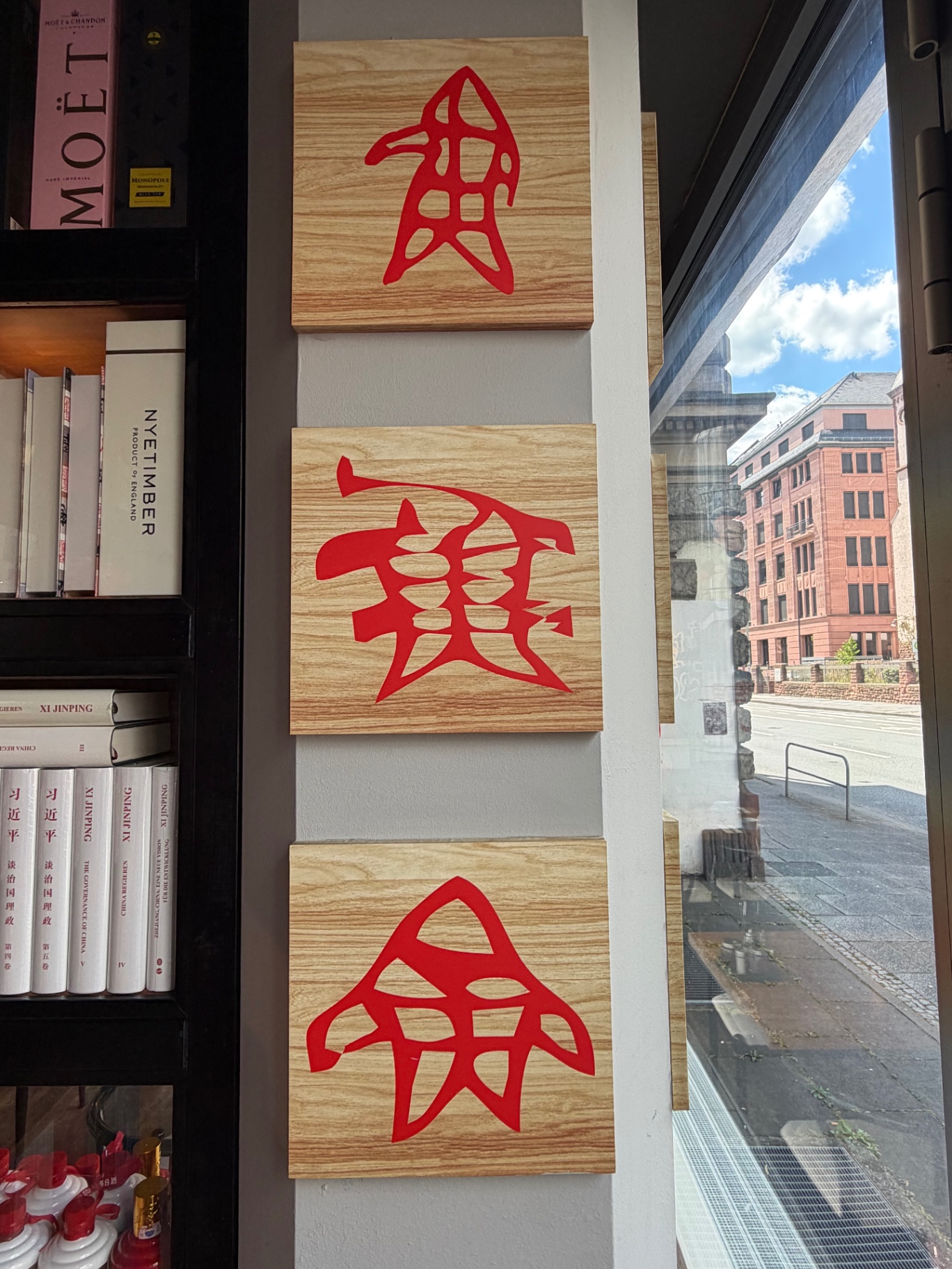 Drei rote chinesische Schriftzeichen auf Holztafeln an der Säule im Eingangsbereich