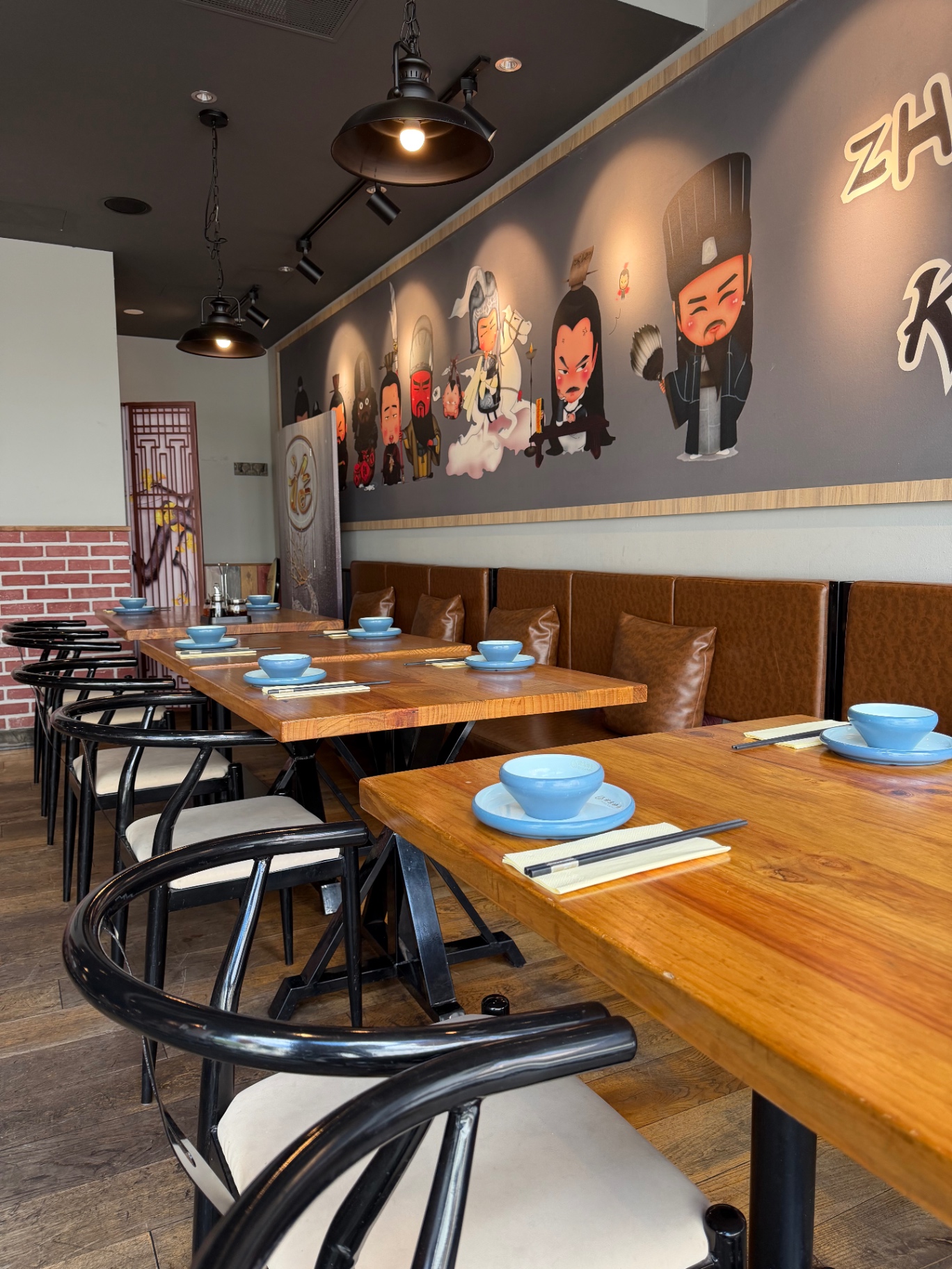 Ledersitzbank entlang der Wand mit ZHUGE KAOYU Maskottchen-Wandbild