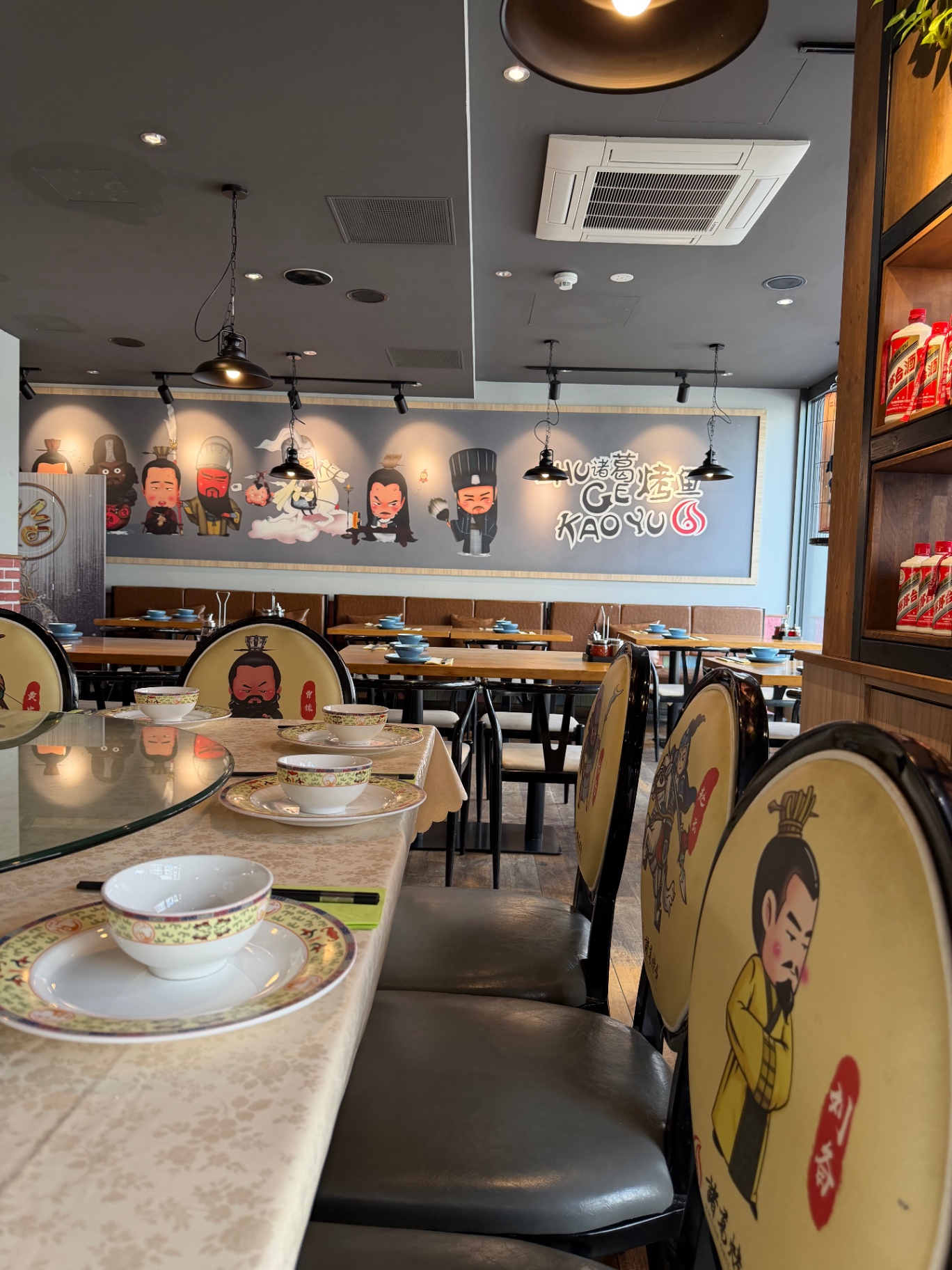 Panorama-Wandbild mit den Maskottchen-Figuren des Restaurants über der Sitzecke